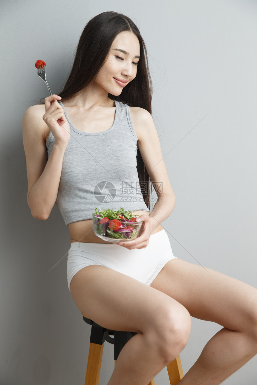 青年女人吃水果沙拉图片