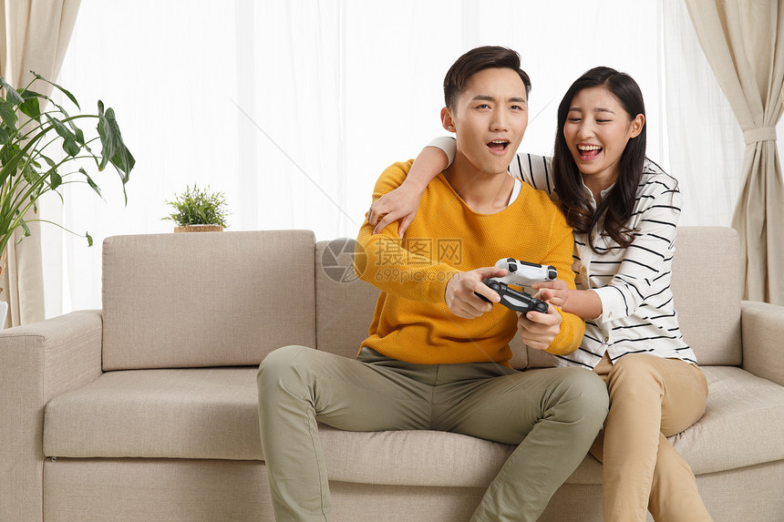 男朋友亚洲亚洲人青年情侣坐着沙发上玩游戏图片