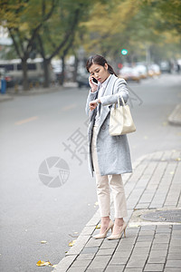 赶时间上班族城市旅行者商务青年女人在路边等出租车背景