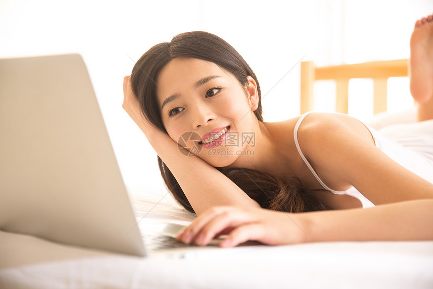 便利成年人清新青年女人在卧室使用电脑图片