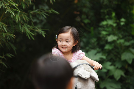 仅女孩儿童玩耍可爱的小女孩在骑摇摆木马图片