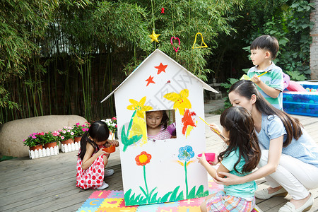 玩具屋青年女人蹲亚洲人幼儿园的师生在做手工背景