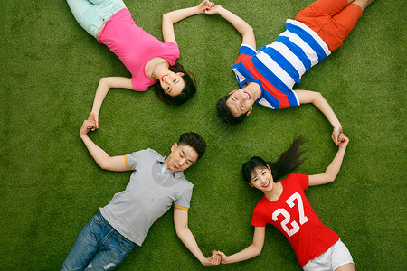 青年男女躺在草地上玩耍休闲装高清图片素材