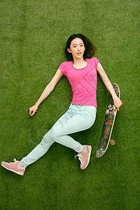 滑板爱好者时尚的青年女人玩滑板背景