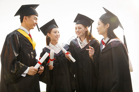 闲聊青年大学生穿着学士服庆祝毕业背景