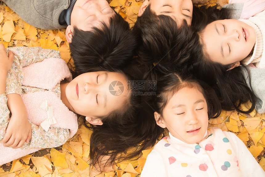 自由放松5到6岁可爱的男孩女孩躺在地上图片