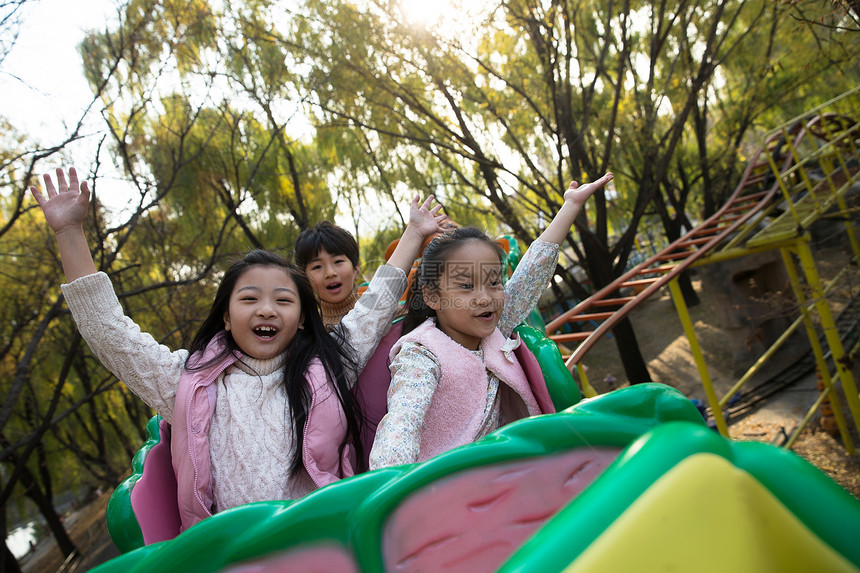 公园娱乐亚洲男孩女孩坐过山车图片