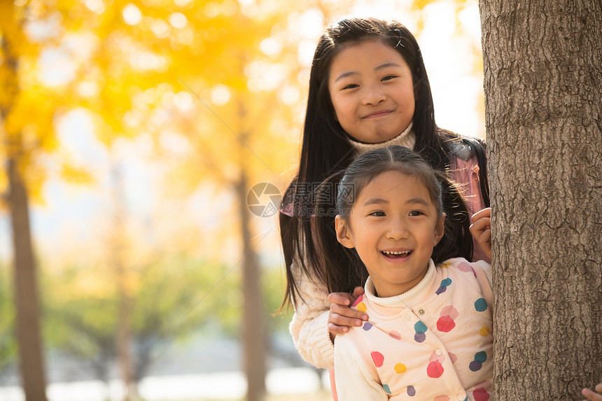 秋天乐趣休闲装两个可爱的小女孩在户外玩耍图片