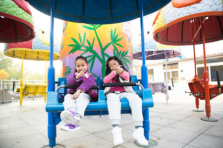 亚洲小学生高兴的两个女孩在游乐场玩耍图片
