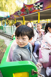 北京公园半身像男孩女孩坐在游乐场玩耍图片