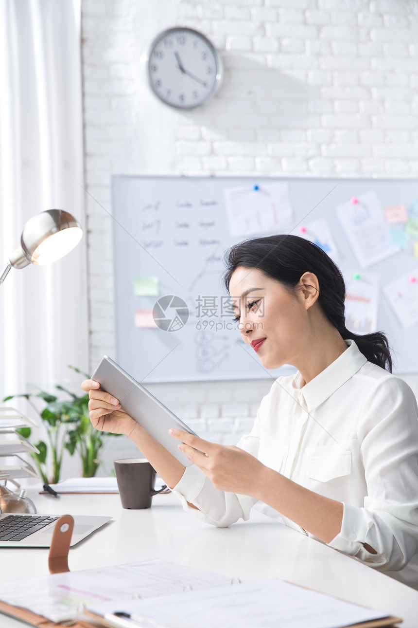 青年商务女人使用平板电脑办公图片