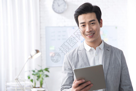 公司企业户内电子商务青年商务男人拿着平板电脑办公图片