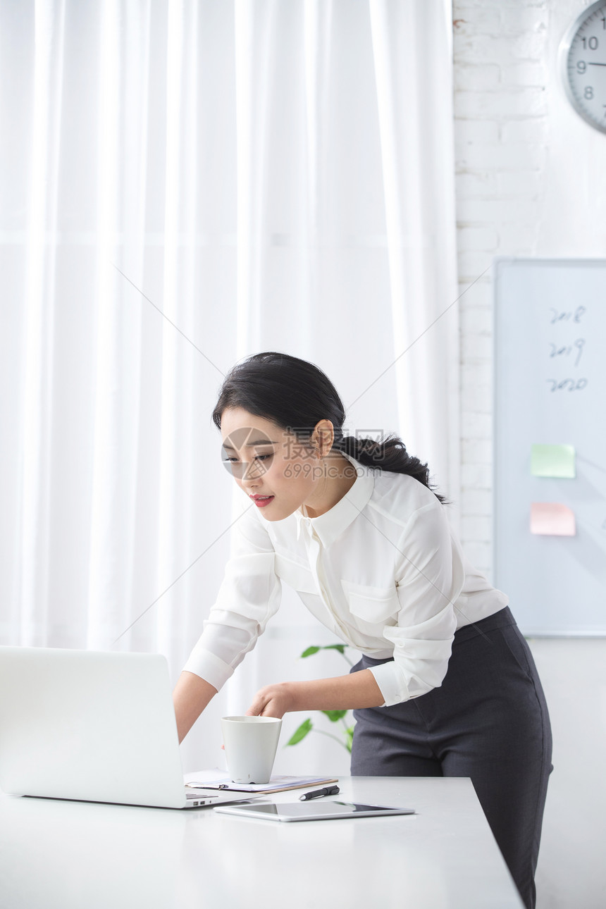 公司企业青年商务女人使用笔记本电脑办公图片