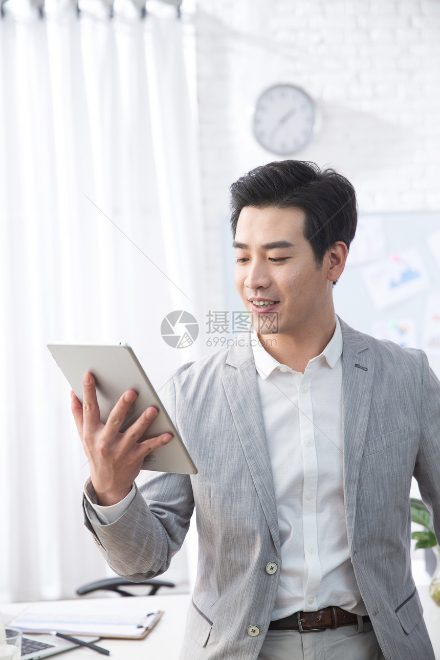 东方人自信青年人青年商务男人拿着平板电脑办公图片