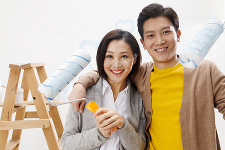 快乐东方人女朋友年轻夫妇装修房子油漆高清图片素材