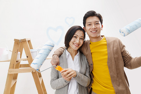 情侣东方人刷漆年轻夫妇装修房子关爱高清图片素材