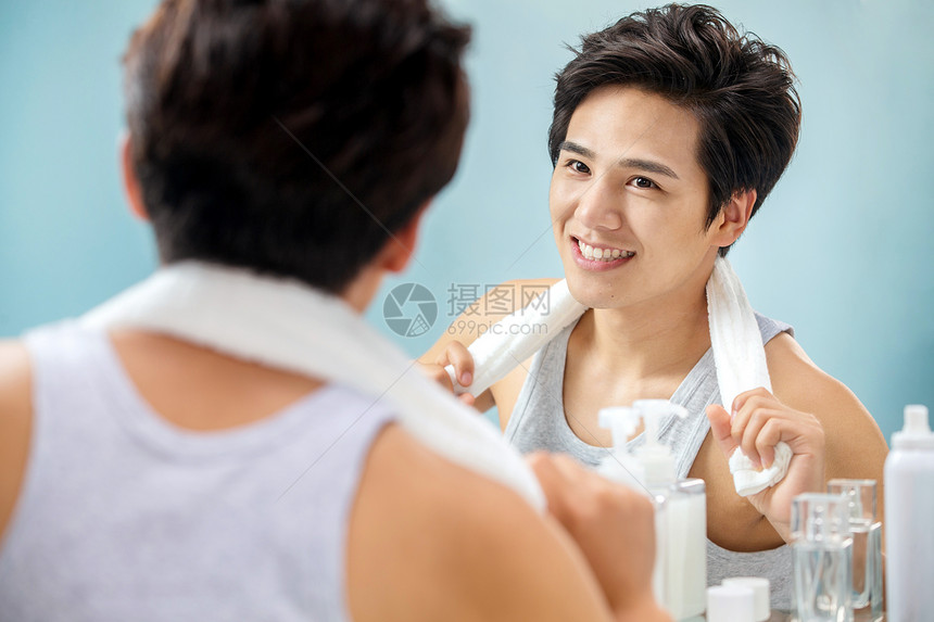 个人护理彩色图片欣赏自信的年轻男人挂着毛巾照镜子图片