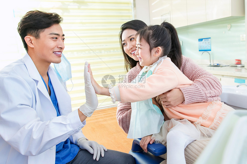 年轻妈妈带着小女孩看牙医图片