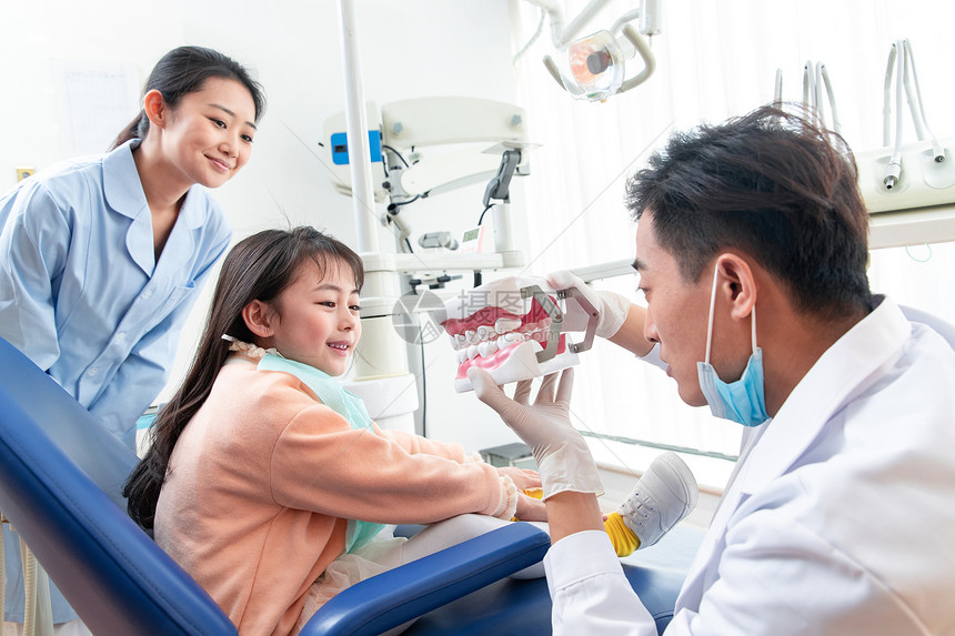 牙科医生教小女孩刷牙图片