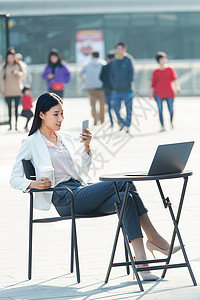 视频通讯城市生活餐厅二郎腿青年商务女士在户外工作背景