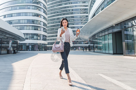 全身像通讯饮食拿着咖啡的商务女看手机高清图片