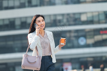 东方人办公室职员信心青年商务女人边走边打电话上下班高清图片素材