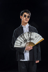 亚洲影棚拍摄传统服装戴墨镜的青年男人图片