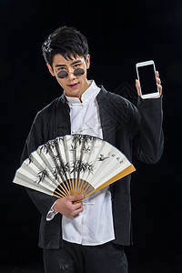 亚洲影棚拍摄扇子戴墨镜的青年男人图片