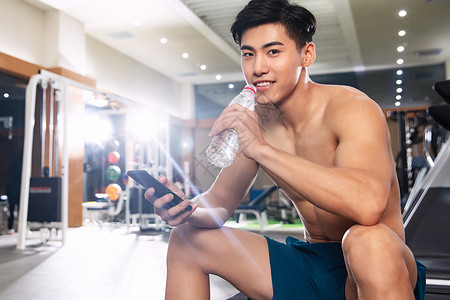 体育场馆健康的休闲活动青年男人在健身房里喝水图片