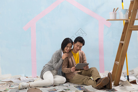 倚靠亚洲人欢乐年轻夫妇装修房子起居室高清图片素材