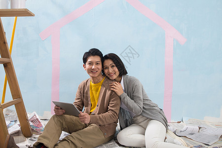 关爱乐趣搂着年轻夫妇装修房子布置高清图片素材