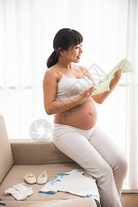 幸福的孕妇准备婴儿用品图片