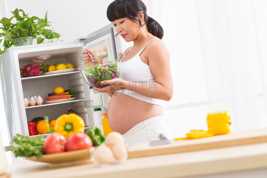 身体保养孕妇打开冰箱拿蔬菜图片