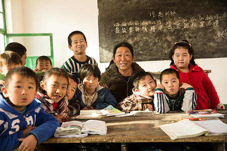 青年节男孩女孩中老年人50到54岁老师乡村女教师和小学生在教室里背景