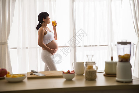 手信新生活手放在肚子上自信孕妇喝果汁背景