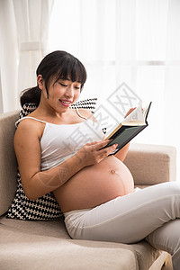 腹部健康的爱孕妇看书图片