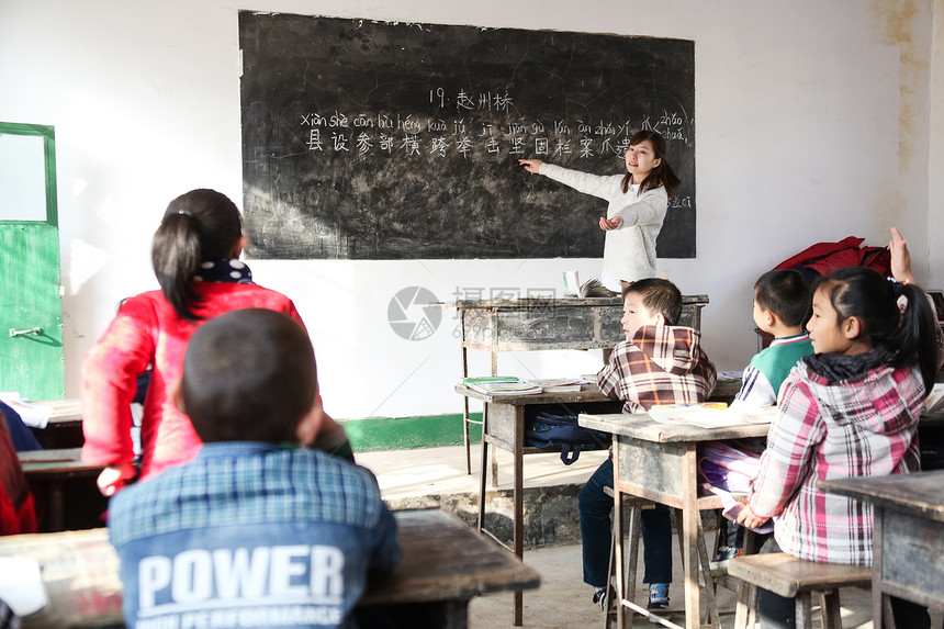 课桌艰苦环境乡村女教师和小学生在教室里图片