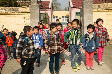 下课回家平房微笑的团结乡村小学生在放学回家背景