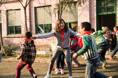 追赶玩耍的学生希望红领巾女生乡村教师和小学生在学校里做游戏背景