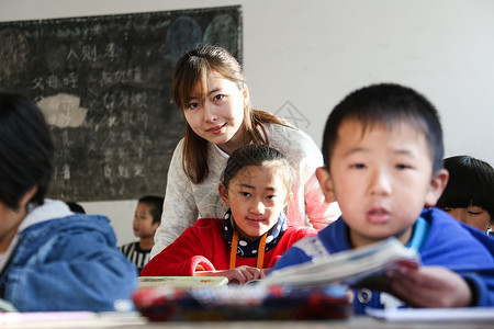 教育友谊乐观乡村女教师和小学生在教室里上课高清图片素材