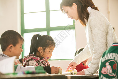 农村少量人群桌子乡村女教师和小学生在教室里高清图片