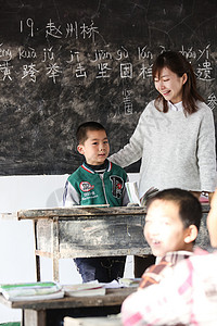 希望小学指导女生乡村女教师和小学生在教室里图片