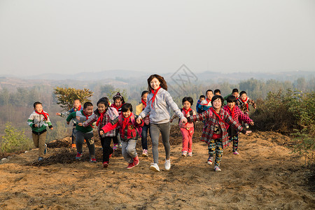 小学女生快乐志愿者乡村女教师和学生在玩耍图片