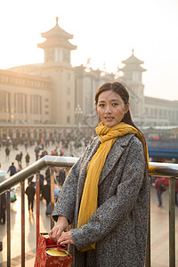 过年旅行者日光青年女人在站前广场背景图片