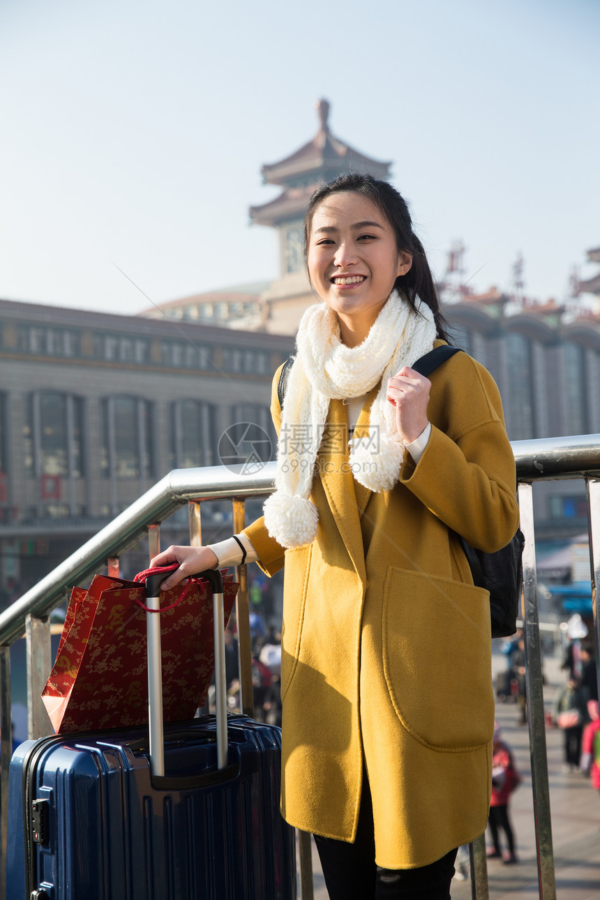 春运围巾旅行青年女人在站前广场图片