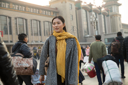 春节东方人旅游青年女人在站前广场背景图片