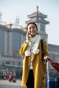 拿着围巾通讯青年女人在站前广场东方人高清图片素材