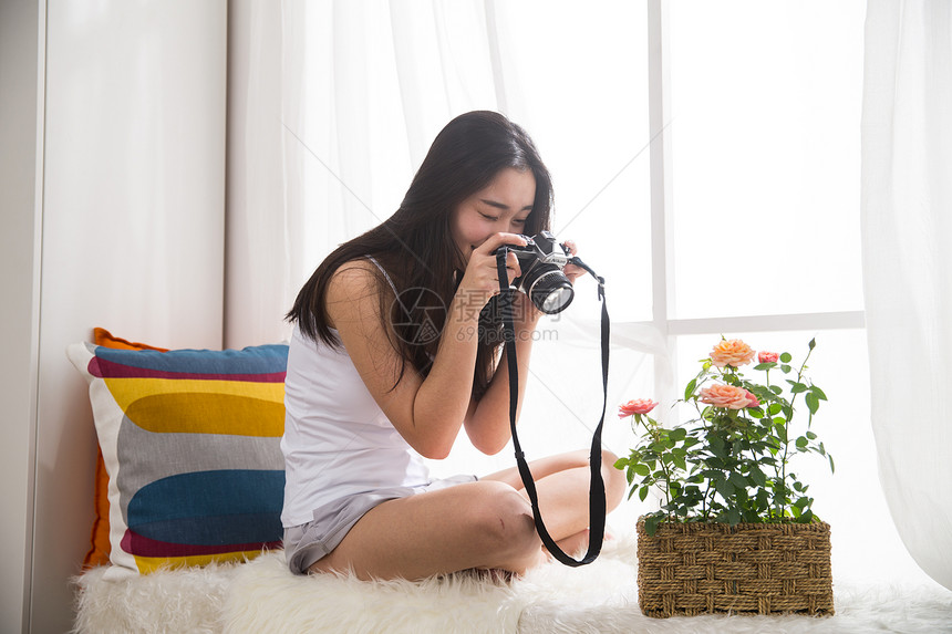 青年女人拿着相机拍照图片