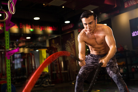 腹肌硬朗锻炼青年男人在健身房健身背景图片