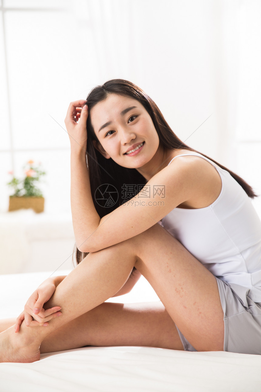 独处垂直构图微笑青年女人在卧室图片